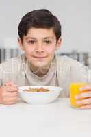 Smiling young boy enjoying breakfast in kitchen