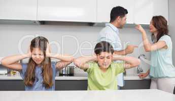 Sad young kids while parents quarreling