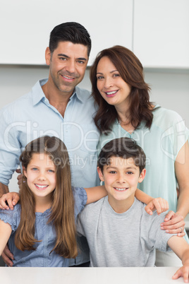 Portrait of a happy family of four in kitchen