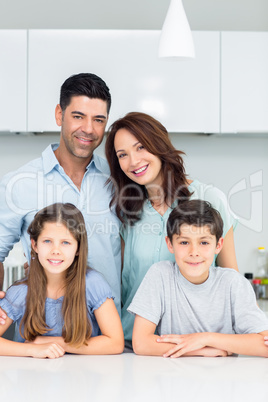 Portrait of a happy family of four in kitchen