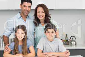 Portrait of a happy family of four in kitchen