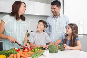 Family chopping vegetables in the kitchen