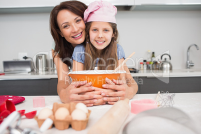 Portrait of a girl and mother preparing cookies in kitchen