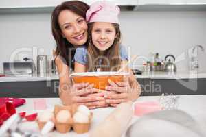 Portrait of a girl and mother preparing cookies in kitchen