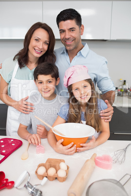 Portrait of family of four preparing cookies in kitchen