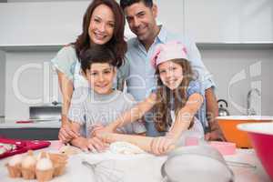 Portrait of a family of four preparing cookies in kitchen