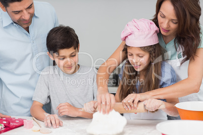 Family of four preparing cookies in the kitchen