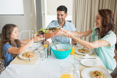 Happy family of three sitting at dining table