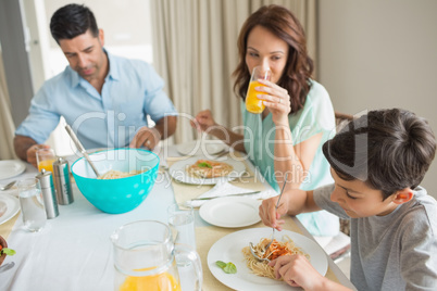 Family of three sitting at dining table