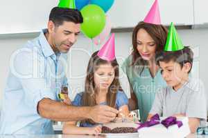 Family of four with cake at a birthday party