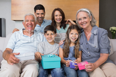 Extended family on sofa with gift boxes in living room