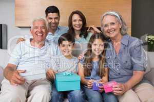 Extended family on sofa with gift boxes in living room