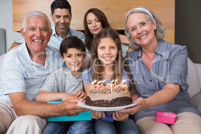 Portrait of extended family with cake in living room