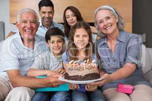 Portrait of extended family with cake in living room