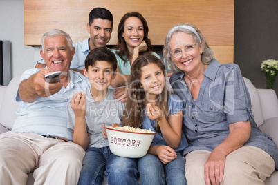 Portrait of happy extended family watching tv in living room