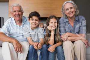 Portrait of grandparents and two kids in living room