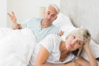 Woman besides man in bed