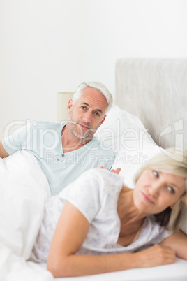 Woman besides man in bed at home