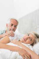 Woman ignoring mature man in bed