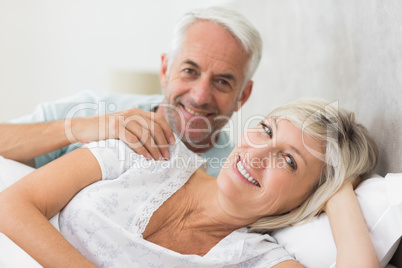 Closeup of a smiling mature couple lying in bed