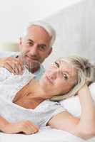 Closeup portrait of smiling mature couple lying in bed