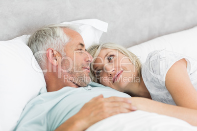 Loving mature couple lying in bed