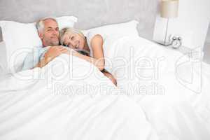 Loving mature man and woman lying in bed