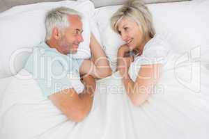 Loving mature couple lying in bed