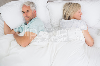 Mature couple lying in bed at home