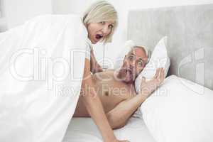 Portrait of mature couple shouting in bed