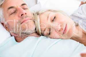 Loving mature couple sleeping in bed