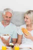 Mature couple having breakfast in bed