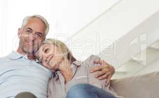 Relaxed mature couple sitting on sofa