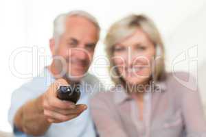 Blurred mature couple watching tv at home