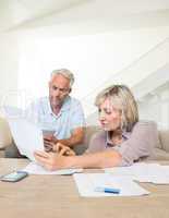 Concentrated mature couple with bills at home