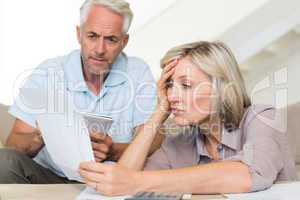 Concentrated mature couple with bills at home