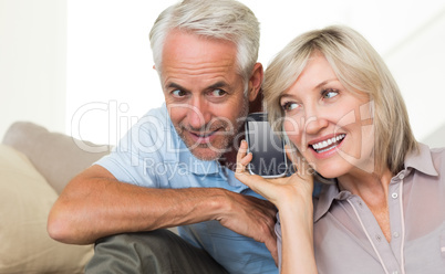 Mature couple using a smartphone on sofa