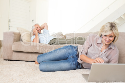 Couple with laptop and cellphone in living room at home