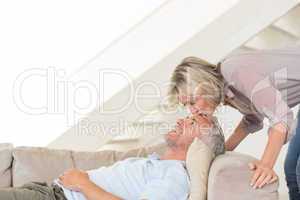 Woman kissing a mans forehead in the living room