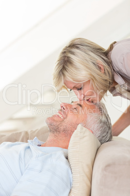 Side view of a woman kissing a relaxed mature mans forehead in t