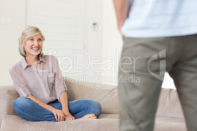 Smiling woman looking at man in living room