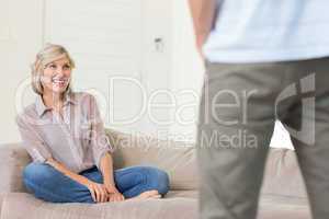 Smiling woman looking at man in living room