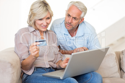 Mature couple doing online shopping at home