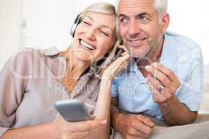 Mature couple with headphones and cellphone