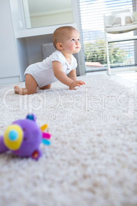 Side view of a baby crawling on carpet