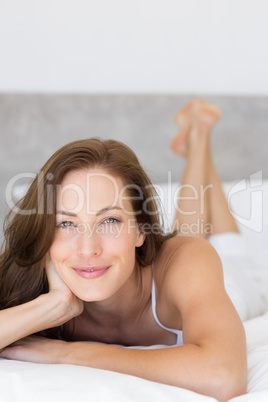 Closeup of a pretty smiling woman lying in bed