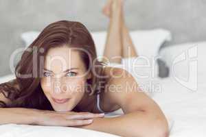 Closeup of a pretty smiling woman lying in bed