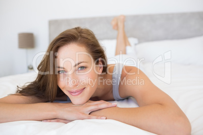 Pretty smiling young woman lying in bed Pretty smiling young woman lying in bed