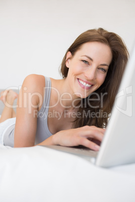 Portrait of relaxed woman using laptop in bed