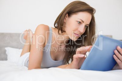 Pretty relaxed woman reading book in bed